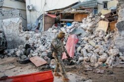 FILE - A soldier walks past rubble in the aftermath of an attack on the Afrik Hotel in Mogadishu, Somalia, Feb. 1, 2021. Al-Shabab claimed responsibility for the deadly assault.