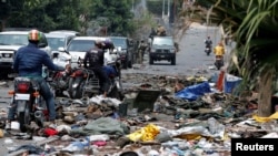 FILE - Motorcyclists look at military uniforms from the Armed Forces of the Democratic Republic of Congo lying on the ground, amid clashes between them and the M23 rebels, in Goma, eastern DRC, Jan. 30, 2025.