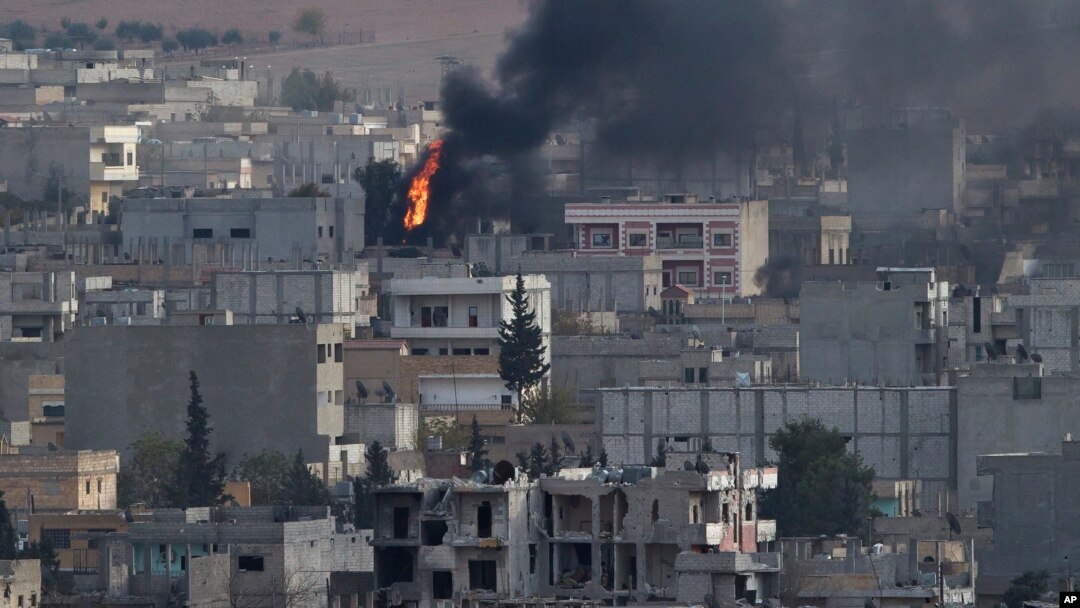 Kebakaran di kota Kobani, Suriah, dilihat dari atas bukit di luar kota Suruc, perbatasan Turki dan Suriah (13/11).