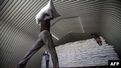 World Food Program workers stack humanitarian aid parcels that will be distributed to South Sudanese refugees, on May 20, 2017, at Al-Obeid airport in Sudan.