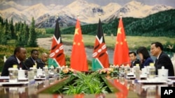 FILE: Then-Kenya President Uhuru Kenyatta, left, talks with Chinese Premier Li Keqiang, right, during their meeting at the Great Hall of the People in Beijing, China , on Aug. 20, 2013.