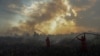 FILE - Firefighters try to extinguish a bush fire in Ogan Ilir regency, South Sumatra, Indonesia, Aug. 4, 2017, in this photo taken by Antara Foto. 