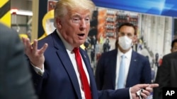 Predsednik Donald Tramp drži masku u ruci tokom obilaska Fordove fabrike u Mičigenu, 21. maj 2020.