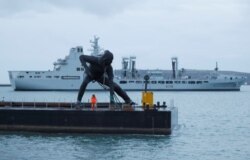 Patung perunggu terbesar Inggris, "Messenger" saat 'transit' di Plymouth Sound dengan tongkang, sebelum dibawa melalui jalan darat ke Theatre Royal di Plymouth, Inggris, 18 Maret 2019. (REUTERS / Peter Nicholls)