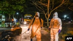 ရန်ကုန်မြို့က Quarantine စင်တာတခုမှာ ပြည်ပက ပြန်လာသူတွေရဲ့ ခရီးဆောင်အိတ်တွေကို ပိုးသတ်ဆေးဖျန်းနေသူနှစ်ဦး။ (မေ ၈၊ ၂၀၂၀)