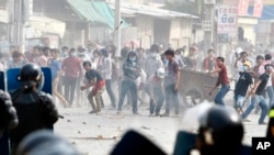 Garment workers throw objects at riot police during a strike near a factory of Canadia Center, on the Stung Meanchey complex at the outskirt of Phnom Penh, Cambodia, Friday, Jan. 3, 2014. 