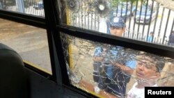 Police officers look at bullet holes in a window that were made during a shooting inside a bus on the Pan-American highway near Ciudad Dario, Nicaragua, July 20, 2014. 