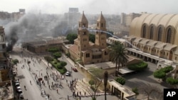 Polisi anti- huru hara melemparkan gas air mata untuk membubarkan bentrokan di kompleks gereja Katedral Koptik Ortodoks di Kairo, Mesir (7/4). Dilaporkan sedikitnya dua orang tewas dalam insiden ini.