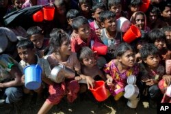 Rohingya Muslim children, who crossed over from Myanmar into Bangladesh, wait squashed against each other to receive food handouts distributed to children and women by a Turkish aid agency at the Thaingkhali refugee camp in Ukhiya, Bangladesh, Nov. 14, 20