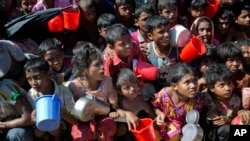 FILE - Rohingya Muslim children, who crossed over from Myanmar into Bangladesh, wait squashed against each other to receive food handouts distributed to children and women by a Turkish aid agency at the Thaingkhali refugee camp in Ukhiya, Bangladesh, Nov. 14, 2017.