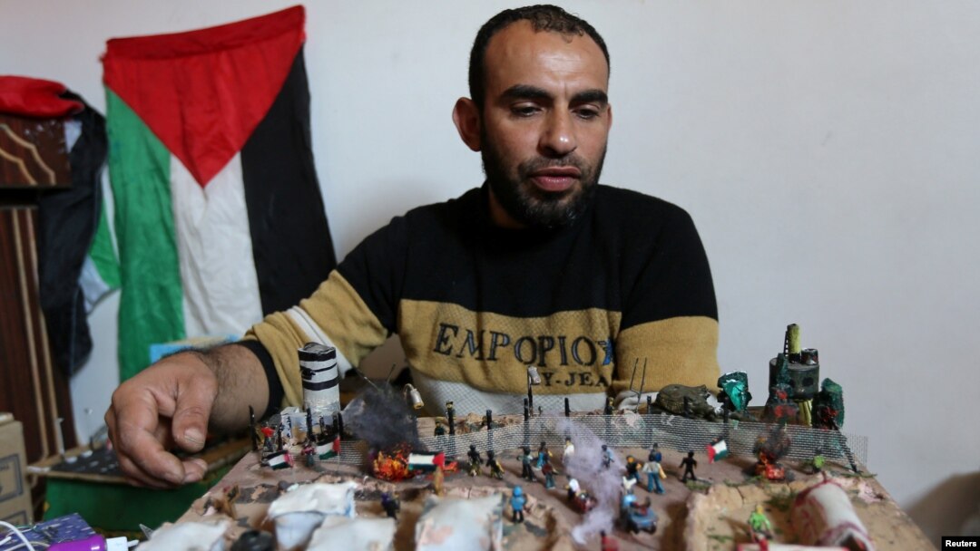 Palestinian artist Majdi Abu Taqeya works on small figures he carves from remains of Israeli ammunition collected from the scenes of border protests along the Israel-Gaza border, in the central Gaza Strip March 11, 2019. REUTERS/Ibraheem Abu Mustafa