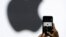 FILE - A person takes a photo of an Apple logo before an announcement of new products at the Apple Worldwide Developers Conference in San Jose, California, June 5, 2017.