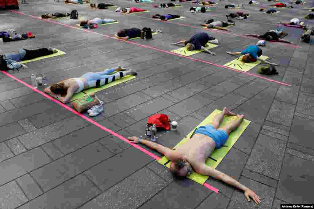 Pessoas participam no evento de celebra&#231;&#227;o do solst&#237;cio na Times Square em Nova Iorque (&quot;Solstice in Times Square: Mind Over Madness Yoga&quot;). 20 de Junho, 2021