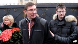 Former Ukrainian Interior Affairs Minister Yuri Lutsenko walks out of his prison to be greeted by his wife, left, and son.