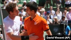 Le Britannique Andy Murray, à gauche, félicite Novak Djokovic de la Serbie a remporté la demi-finale du l’ Open français du tennis en cinq sets 6-3, 6-3, 5-7, 5-7, 6-1, au stade Roland-Garros, à Paris, France, 6 Juin, 2015. (AP Photo / David Vincent)