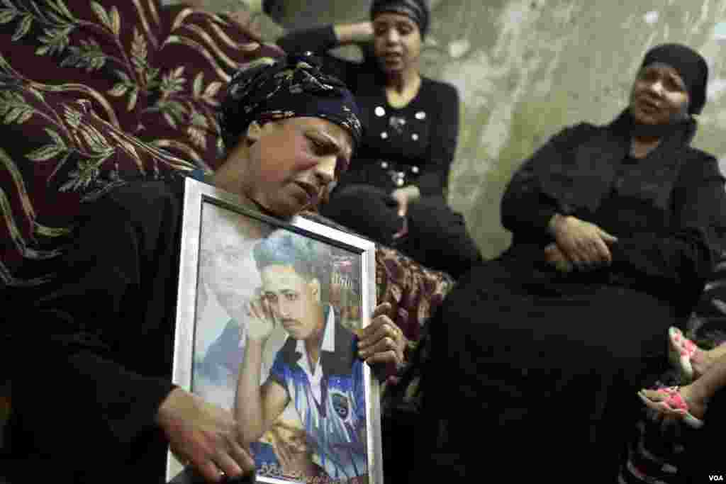 A woman holds a photo of her son, a Coptic man who was killed during a terror attack in 2016, as the man&rsquo;s sister and aunt cry during his funeral in Cairo, Egypt. Terror attacks targeting Copts increase near their Christmas on Jan. 7.