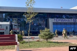 FILE - Law enforcement officers patrol an area outside the airport in Makhachkala on October 30, 2023.