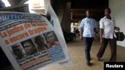 Des Ivoriens passent devant Le Nouveau Courrier, qui a, à sa Une, une photographie de Simone Gbagbo, à Abidjan, le 10 mars 2015. 