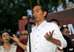 FILE - Indonesian president-elect Joko Widodo gestures as he speaks to his supporters during a gathering in Jakarta.