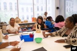 Stacey Stevens, director of an early childhood regional training center for the Kentucky Department of Education, completes an exercise using standard unit blocks, at the Erickson Institute's summer learning program. (Camilla Forte/The Hechinger Report via AP)