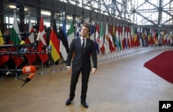 French President Emmanuel Macron speaks with the media as he arrives for an EU summit in Brussels, March 21, 2019.