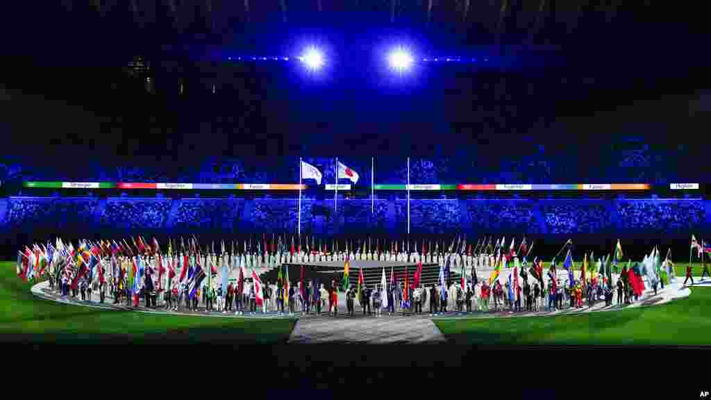 Flags are carried in during the closing ceremony in the Olympic Stadium at the 2020 Summer Olympics, Sunday, Aug. 8, 2021, in Tokyo, Japan. (AP Photo/Charlie Riedel)