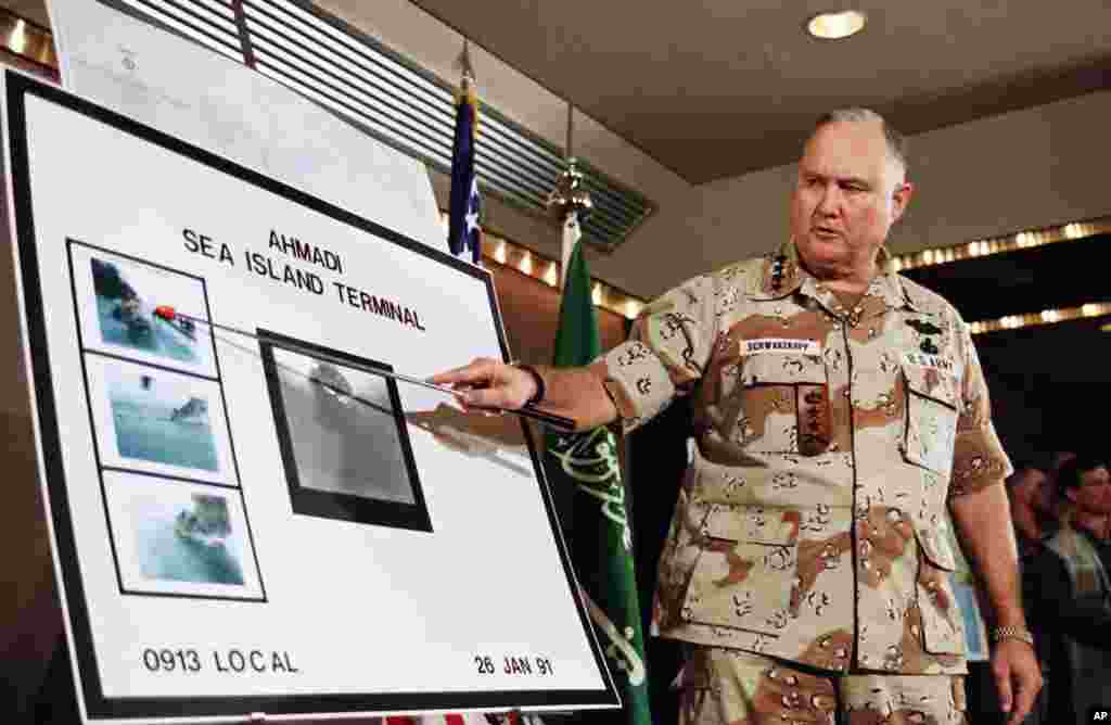 Schwarzkopf, num encontro com jornalistas, aponta fotos de alvos a arder ap&oacute;s um bombardeamento americano durante a Guerra do Golfo de 1991