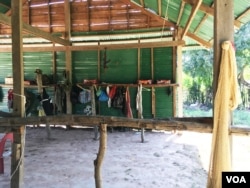 An AK-47 assault rifle and camouflage accessories hang inside the makeshift military base camp in Srey Snam district's Tram Sasar commune on Dec. 21, 2017. (Sun Narin/VOA Khmer)