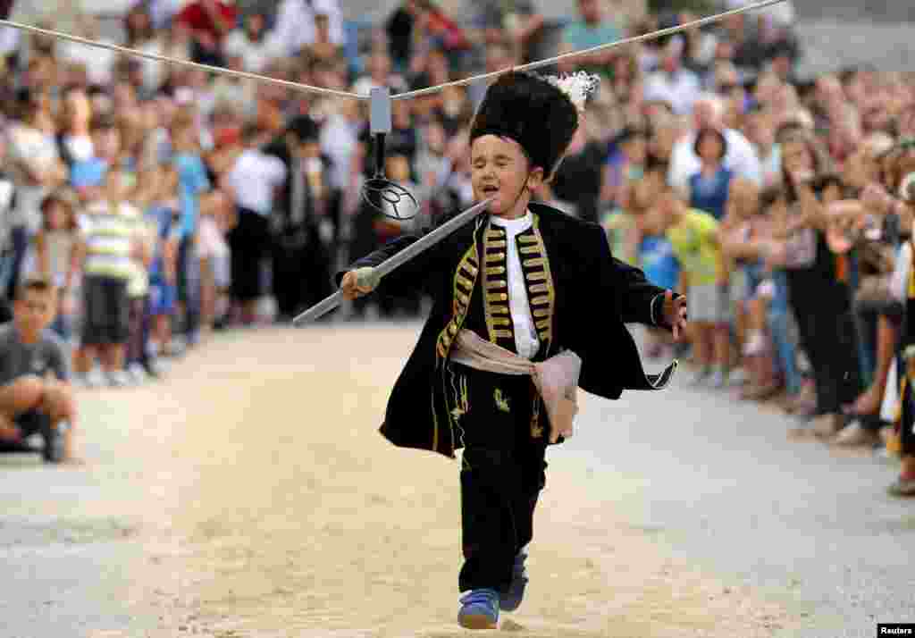 A child runs during the Children&#39;s Alka competition in Vuckovici village, Croatia, Aug. 23, 2015.