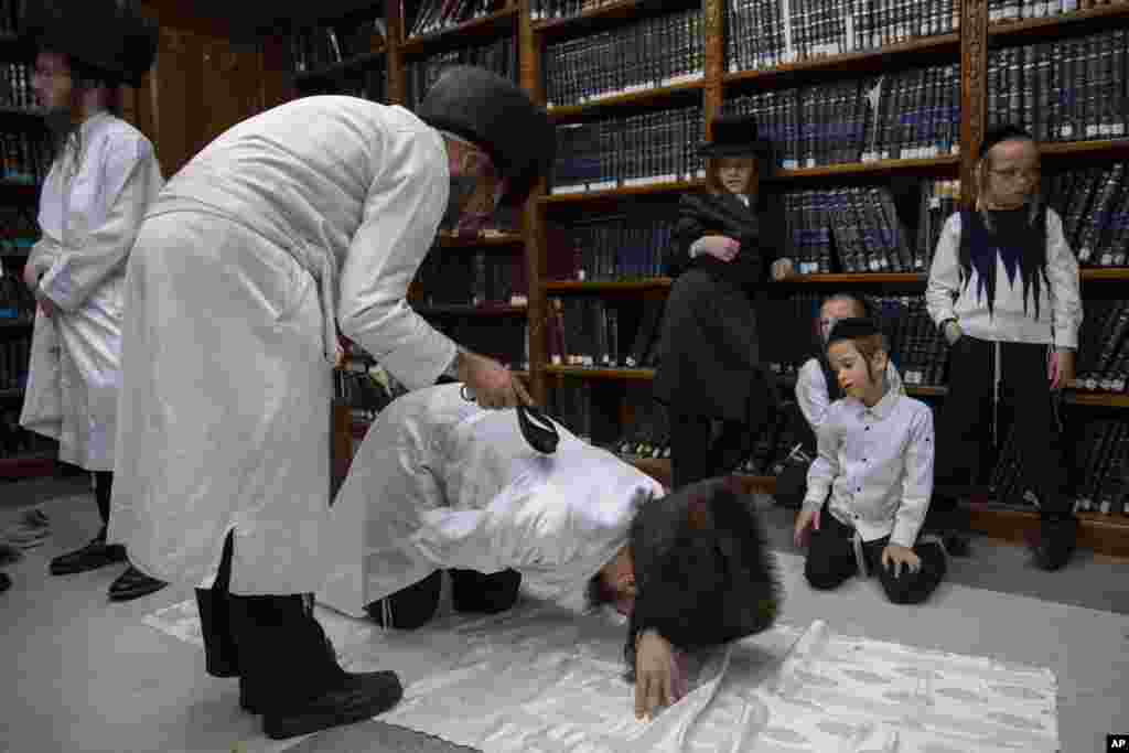 Ortodoksni jevrejski vernik bičuje hasida kožnim remenom kao simboličnu kaznu za grehe u protekloj godini pred Jom Kipur, koji počinje sa zalaskom sunca. Beit Šemeša kod Jerusalima, 15. septembra, 2021. ( Foto: Oded Balilty / AP )