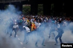 Manifestantes são afastados com gás pelas forças de segurança, durante um protesto da oposiºão em Caracas, capital da Venezuela, 6 de Abril, 2017.