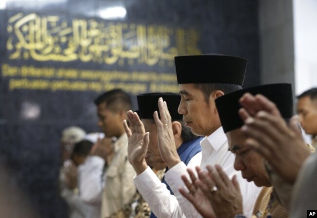 Presiden Joko Widodo (tengah) melakukan sholat Jumat di masjid di Tanah Tinggi, Jakarta, 26 Juli 2019.