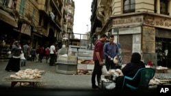 FILE -- A woman sells bread near the Tawfiqia market in downtown Cairo, Egypt, Oct. 18, 2016. Shortages and rising food prices are feeding discontent among Egyptians, who are also enduring new taxes and a hike in utility bills.