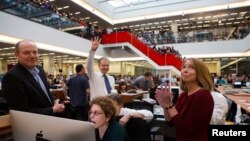 FILE - With Executive Editor Jill Abramson, right, publisher Arthur Sulzberger Jr. holds up four fingers to indicate the four Pulitzer Prizes won by the New York Times, as winners for the 2013 Pulitzer Prize are announced in the newsroom in New York.