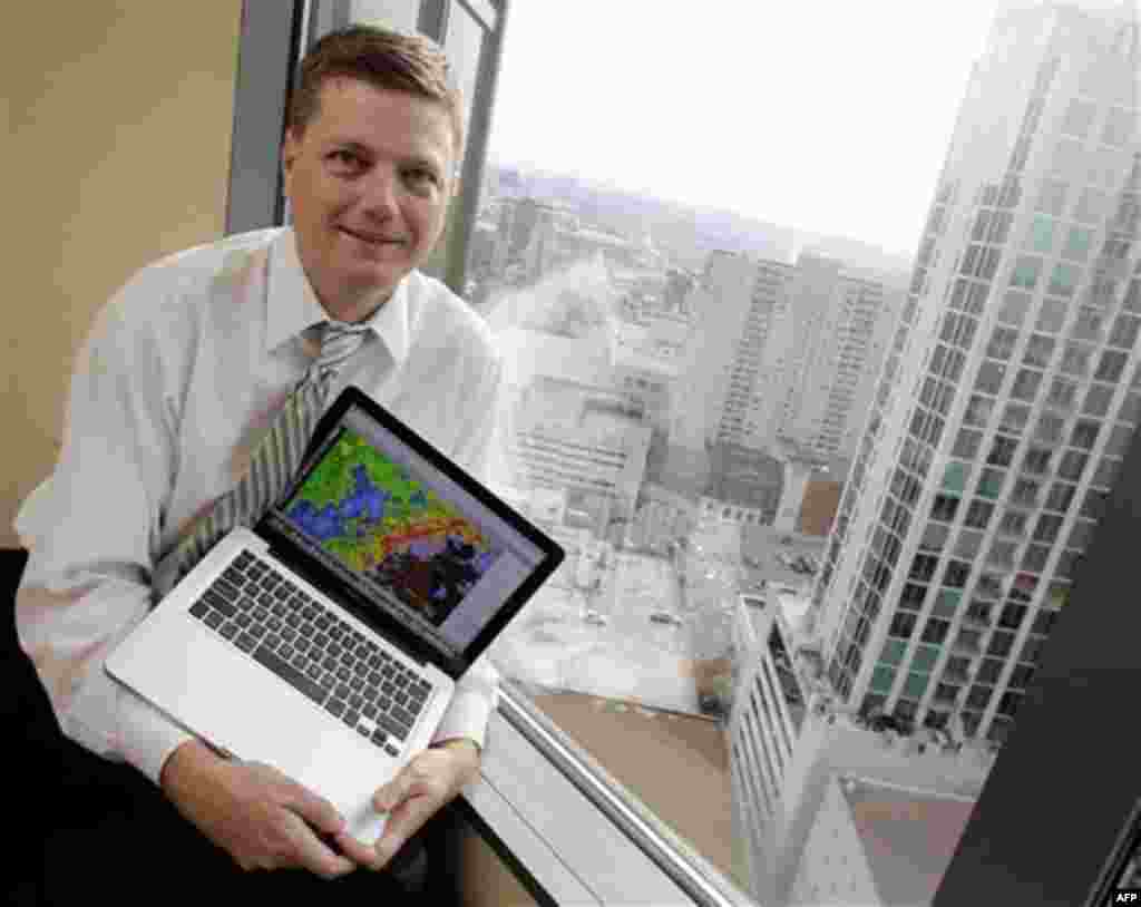 In this Aug. 15, 2011 photo, attorney David Drobny holds the laptop computer he uses to alert report severe weather conditions on his Twitter account in Nashville, Tenn. The view from his office building often gives him a first-hand account of developing 