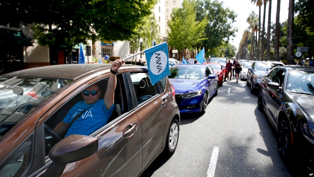 In this Aug. 28, 2019, file photo, dozens of supporters of a measure to limit when companies can label workers as independent contractors circle the Capitol during a rally in Sacramento, Calif. (AP Photo/Rich Pedroncelli, File)