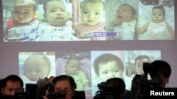 FILE - Surrogate babies that Thai police suspect were fathered by a Japanese businessman who has fled from Thailand are shown on a screen during a news conference at the headquarters of the Royal Thai Police in Bangkok.