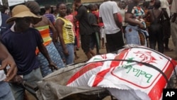 A man, left, renting out his wheelbarrow moves food goods for people in the West Point area that have been hardest hit by the Ebola virus spreading in Monrovia, Liberia, Monday, Aug. 25, 2014. A Liberian doctor who was among three Africans to receive an experimental Ebola drug has died, the country's information minister said Monday. (AP Photo/Abbas Dulleh)