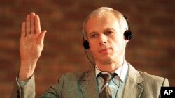 FILE - In this Monday, Nov. 24,1997 file photo. Polish immigrant and convicted killer Janusz Walus is sworn in during a Truth and Reconcilliation Commission hearing in Mamelodi, South Africa.