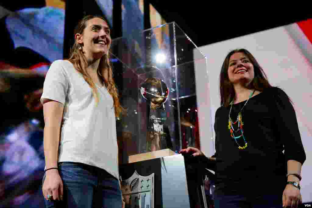 Fans pose with the Vince Lombardi Trophy, which is awarded annually to the winner of the NFL championship game, also known as the Super Bowl. The two football teams playing this year are the New England Patriots and the Atlanta Falcons. (B. Allen/VOA)