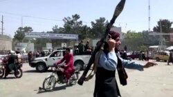 A Taliban fighter runs towards a crowd outside Kabul airport, Kabul, Afghanistan, Aug. 16, 2021, in this still image taken from a video. (REUTERS)