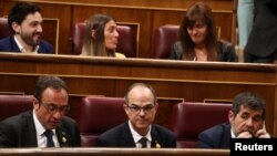 FILE - Jailed Catalan politicians Jordi Sanchez, Josep Rull and Jordi Turull attend the first session of parliament following a general election in Madrid, Spain, May 21, 2019.