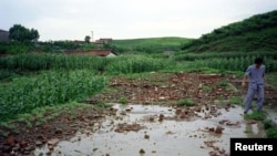 지난 1996년 8월 북한 은파군에서 폭우와 홍수에 무너져 떠내려온 건물 잔해가 농지를 덮었다.