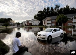 Augustin Dieudomme looks out at the flooded entrance to his apartment complex near the Cape Fear River as it continues to rise in the aftermath of Hurricane Florence in Fayetteville, N.C., Sept. 18, 2018.