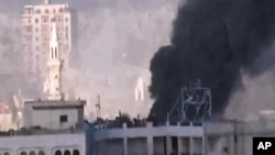 In this image made from amateur video released by the Shaam News Network and accessed May 30, 2012, purports to show black smoke leaping the air from shelling in Homs, Syria. 