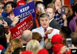 Television personality Sean Hannity speaks to members of the audience while signing autographs before the start of a campaign rally with President Donald Trump in Cape Girardeau, Mo., Nov. 5, 2018.