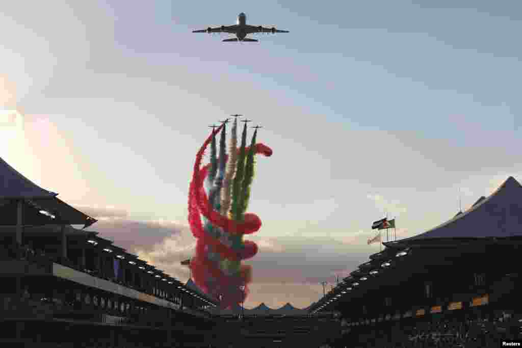 An Etihad Airways&#39; Airbus A380 and UAE&#39;s Al-Fursan aerobatic team perform at the Yas Marina circuit before the start of the Abu Dhabi Formula One Grand Prix.