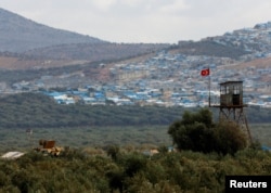 FILE - A Turkish military armored vehicle patrols on the border line located opposite the Syrian town of Atimah, Idlib province, in this picture taken from Reyhanli, Hatay province, Turkey, Oct. 10, 2017.