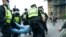 Police detain a man during a coronavirus anti-lockdown protest on Westminster Bridge in London, Oct. 24, 2020. 