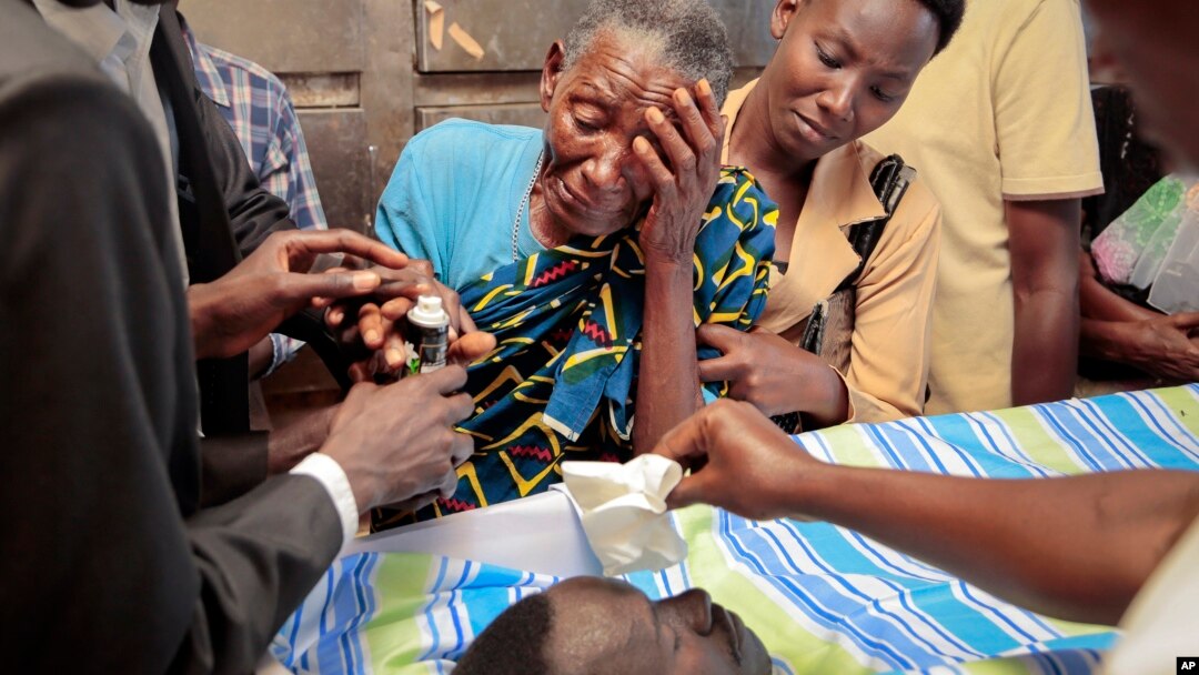 Relatives mourn over the body of Theogene Niyondiko, shot dead Friday by police during a protest against a third term for President Pierre Nkurunziza, in Bujumbura, Burundi, June 9, 2015.